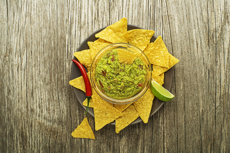 Guacamole sauce with corn nachos chips on plateの写真素材