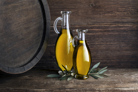 Bottles of Extra virgin healthy Olive oil with barrel backgroundの写真素材