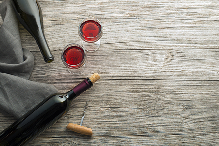 Bottle of red wine with label on old board. Glass of wine and cork. Wine bottle mockup. Top viewの写真素材