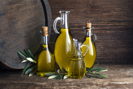 Bottles of Extra virgin healthy Olive oil with barrel backgroundの写真素材