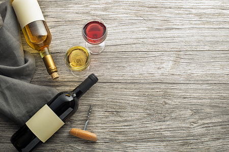 Glass and bottle of red and white wine on wooden background. Wine bottle mockup. Top viewの写真素材