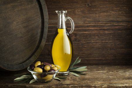 Bottle of Extra virgin healthy Olive oil with barrel backgroundの写真素材