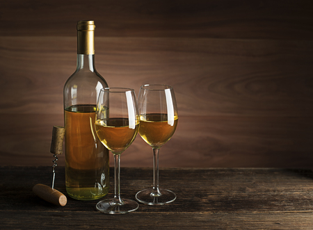 Bottle of white wine with wine glasses on wooden backgroundの写真素材