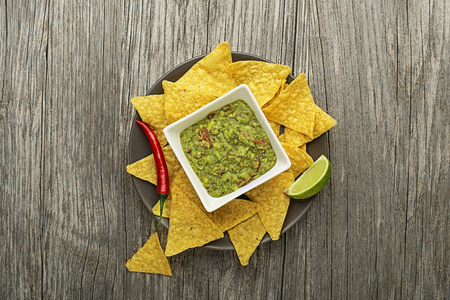 Guacamole sauce with corn nachos chips on plateの写真素材