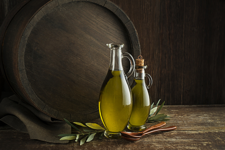 Bottles of Extra virgin healthy Olive oil with barrel backgroundの写真素材
