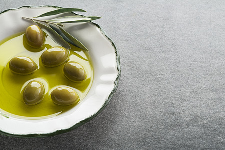 Extra virgin healthy Olive oil with fresh olives close upの写真素材