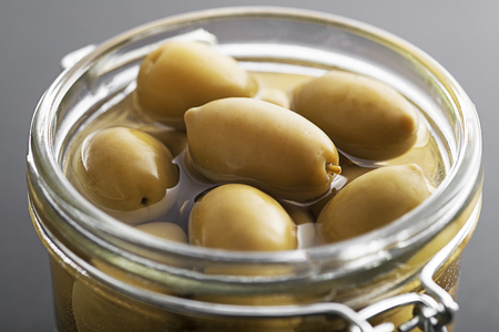 Pickled green olives in glass jar close upの写真素材