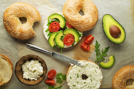 Vegetarian Bagel sandwich with cheese cream, avocado and tomato. Healthy vegetarian and vegan food.の写真素材