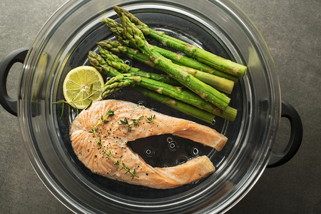 Steamed salmon with fresh herbs. Fresh meal with Salmon file with asparagus on steam. Steam salmon steakの写真素材