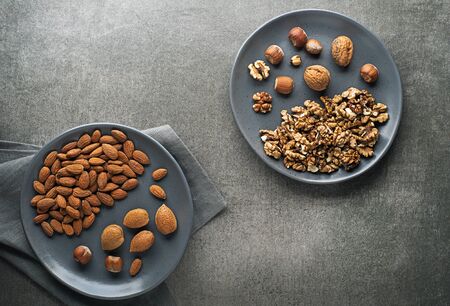 Assortment of nuts in plate. Hazelnuts, walnuts and almondsの写真素材
