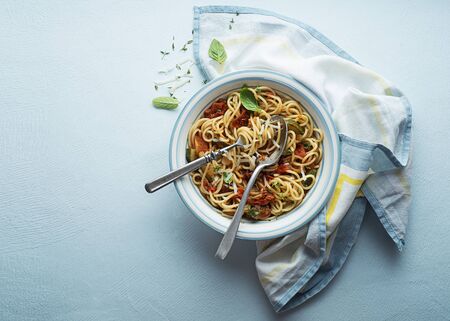 Tasty appetizing classic italian spaghetti pasta with tomato sauce, cheese parmesan and basil on plate. View from above, horizontalの写真素材