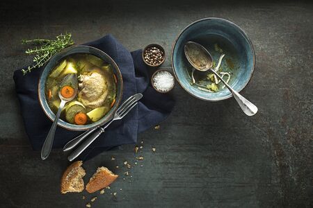 Eating Healthy Chicken soup with vegetables and herbs on dark backgroundの写真素材
