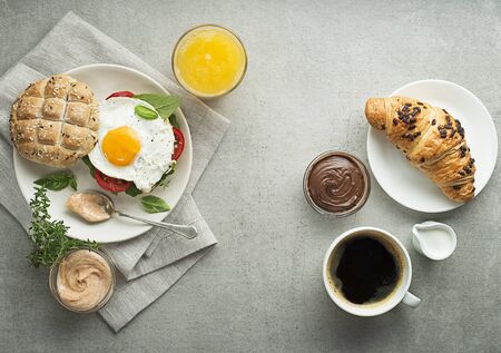 Breakfast served with orange juice, sandwich with egg, croissants and coffee. Delicious healthy breakfast.の写真素材