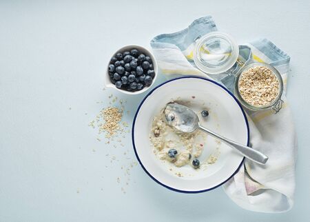 Eating porridge oatmeal with fruits, berries, and honey. Concept of healthy breakfast, wellbeing, healthy eating, dieting and weight lossの写真素材