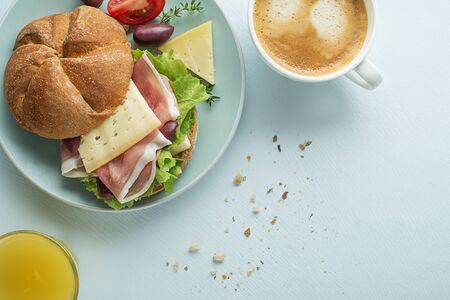 Breakfast served with coffee, juice, sandwich with ham, cheese, tomato and lettuce. Continental delicious healthy breakfast tableの写真素材