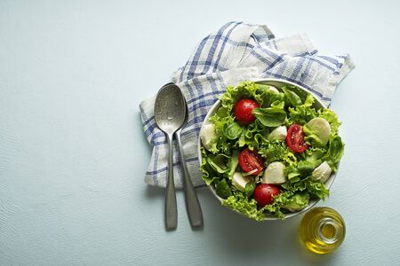 Healthy green salad with tomato and mozzarella cheese.の写真素材