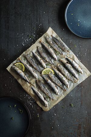 Grilled sardines with lemon and herbs close up. Healthy vegetarian fish mealの写真素材