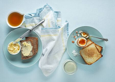 Breakfast served with boiled egg, honey and butter. Delicious good breakfast.の写真素材
