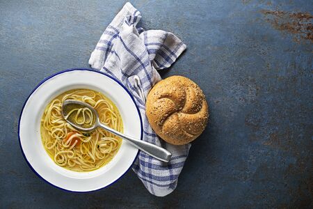 Served hot Hen and Chicken soup with noodles and bread, a place for text. Healthy meal. 