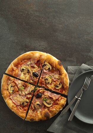 Pizza served with mozzarella cheese, ham, mushrooms and tomato sauceの写真素材