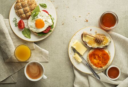 Breakfast served with sandwich with egg, honey with butter and orange juice, coffee.の写真素材