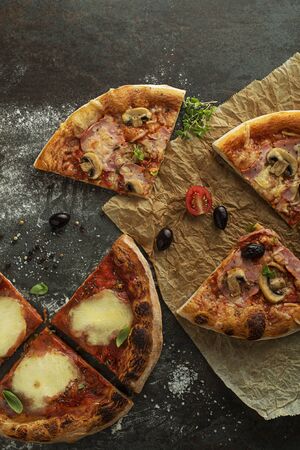 Pizza slices served with mozzarella cheese, ham, mushrooms and tomato sauceの写真素材