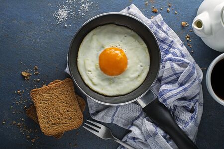 Continental Breakfast meal of fried egg in pan served with bread and coffee top view. Healthy breakfast tabel.の写真素材