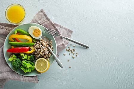 Healthy salad meal with quinoa, egg and mixed freash vegetables on blue background top view. Food and health. Healthy meal conceptの写真素材