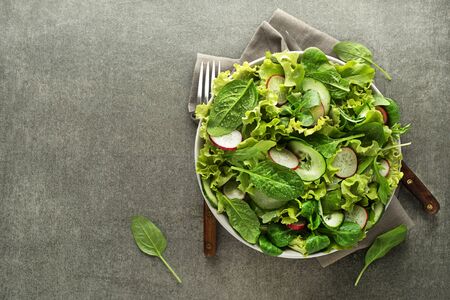 Healthy Green salad with fresh vegetables on grey table backgroundの写真素材