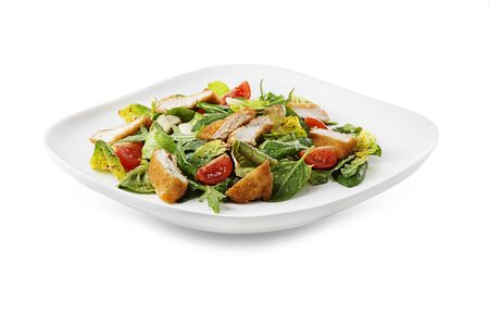 Healthy green salad with crispy fried breaded chicken breast strips and tomatoes isolated on white backgroundの写真素材