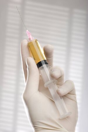 Injection with vaccine in a glass tube close up shoot.の写真素材