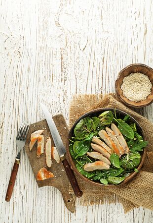 Healthy green salad with chicken breast on wooden tableの写真素材