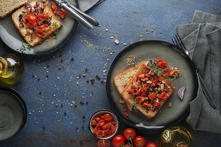 Breakfast served with toast sandwiches with tomato, onion and herbs. Bruschetta with roasted tomatoes. Continental delicious healthy breakfast tableの写真素材