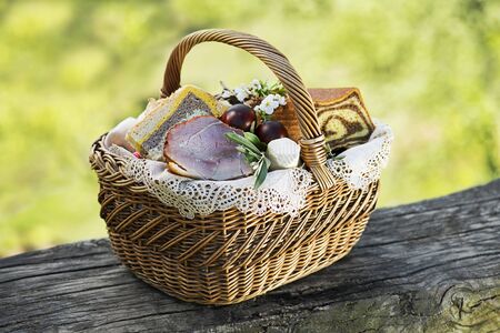 Easter traditional food with ham, eggs and bread in basket. Holidays background outdoorの写真素材