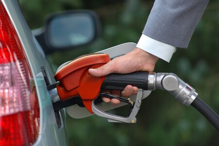 Man pumping petrol with fuel pump. Vehicle fueling facility at petrol station. Petrol price goes down after pandemic coronavirus. low price of fuel.の写真素材