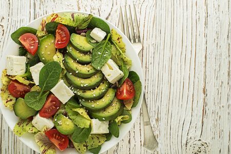 Healthy green salad with avocado and feta cheese close upの写真素材