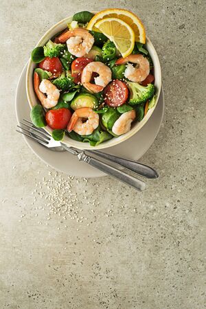 Healthy green salad with grilled shrimps and vegetables on grey background. Grilled prawns. Healthy food. Seafood.の写真素材