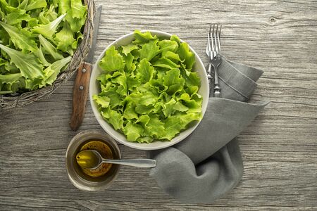 Healthy Green lettuce salad on wooden table background. Freshly picked of young green leavesの写真素材