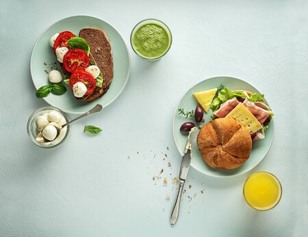Breakfast served with juice and sandwiches with ham, cheese, tomato and lettuce. Continental delicious healthy breakfast tableの写真素材