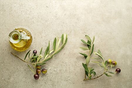 Bottle of olive oil and Branch with olives and leaves background close up. Healthy olive oil conceptの写真素材