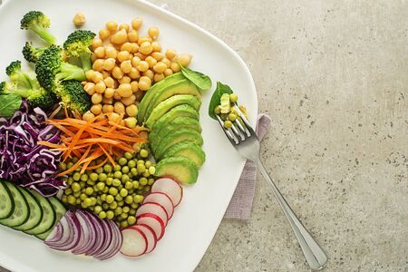 Healthy vegan lunch bowl. Vegetable salad with Avocado, chickpeas, red cabbage, green peas, red...