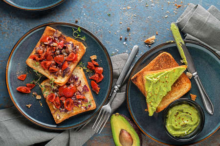 Vegetarian snack with tomatoes and avocado spread with herbs on bread , top view. Healthy food concept.の写真素材