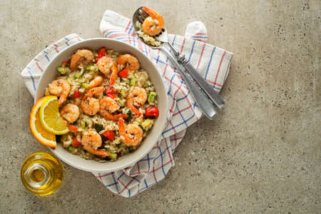 Healthy risotto meal with grilled shrimps and vegetables on grey background. Grilled prawns. Healthy food. Seafood.の写真素材