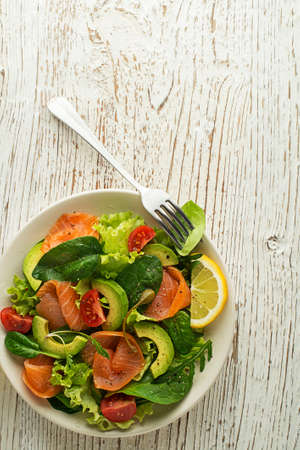 Fresh green lettuce salad with smoked salmon and avocado close upの写真素材