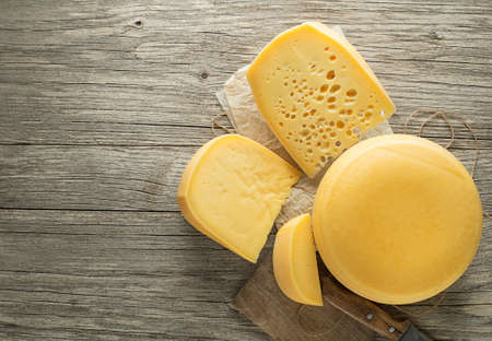 Various types of cheese on rustic wooden table. Top view. Free space for text.の写真素材