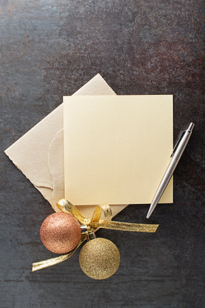 Christmas greeting card template. Empty paper mock up with christmas balls decoration with pen on dark backgroundの写真素材