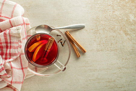 Mulled red wine with spices and fruits on grey table. Traditional hot drink at holiday winter timeの写真素材