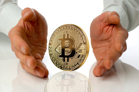 Business men holding bitcoin between hands on white. Bitcoin as most important cryptocurrency conceptの写真素材