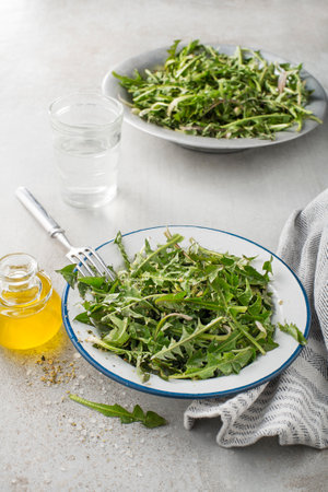 Fresh dandelion salad with dressing. Healthy spring food meal.の写真素材