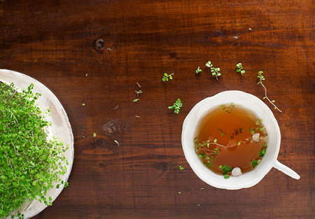 Tea Cup of fresh herbal leaves on wooden background, top view, place for text. Healthy conceptの写真素材